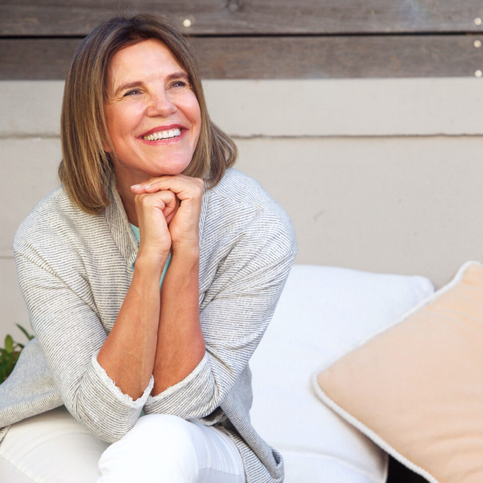 older white women smiling away from the camera with outside background