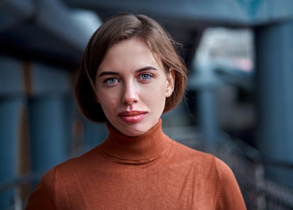 women looking at the camera with a straight face and orange shirt